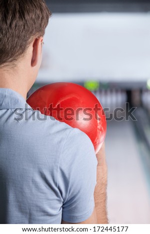 Bowling. Closeup of man holding a bowling ball focusing for a roll,rear view.