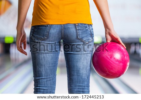 Bowling. Closeup of woman holding a bowling ball focusing for a roll,rear view