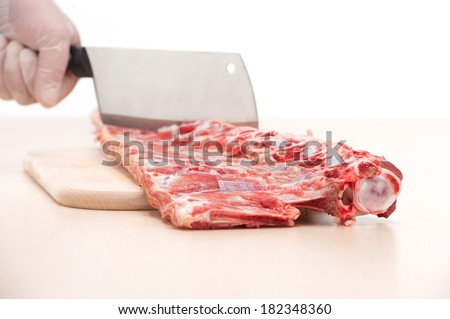 butcher cutting meat on chopping board, professional cook holding knife and cutting meat