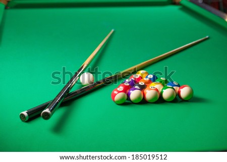 Billiards. Top view of billiard balls and cues on green table