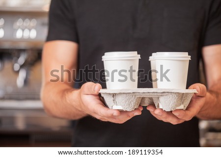 Enjoy Your Drinks. Coffee shop worker two disposable cups with blank sleeves