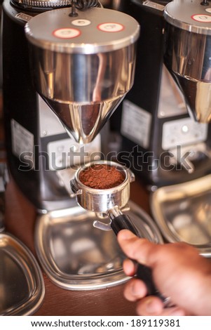 This is ground to be flavorful. Cropped shot of a barista preparing ground coffee for brewing