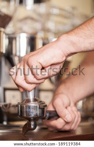 The process to making your coffee. Close up a barista making coffee through the devices of the coffee machine