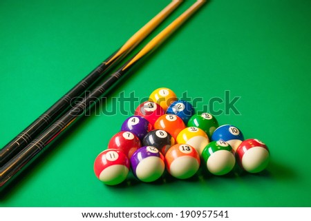Billiards. Top view of billiard balls and cues on green table