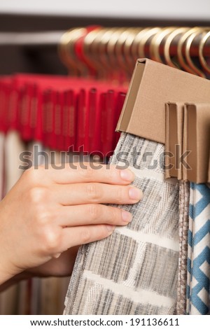 Fabric shop. Woman\'s hands checking the material quality of some fabric