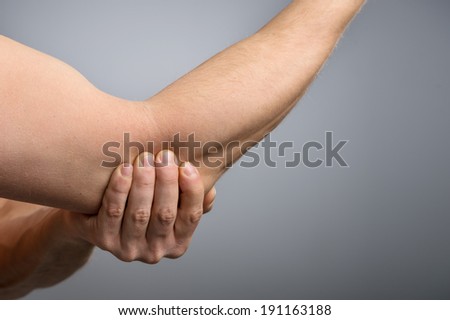 Pnful Elbow Injury. Man in pain, holding elbowai