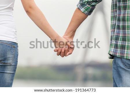 Couple holding hands. Couple holding hands while walking along quay