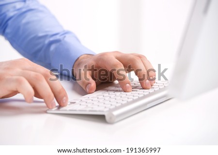 Entering document. Close-up of male hands pressing  key on white keyboard