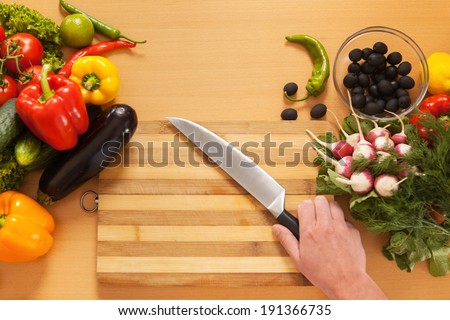 Top View Cutting Board. Vegetables and kitchen knife on cutting board