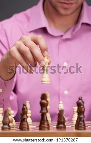 Competition. A chess player, or businessman, making his next chess move.