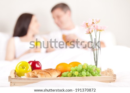 Breakfast in bed. Happy romantic couple eating breakfast in bed