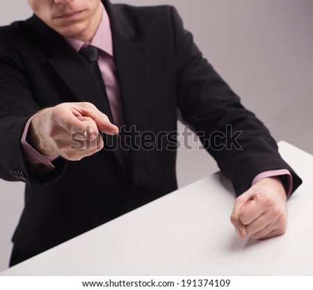 Angry boss. Man in suit banging his fist on the desk