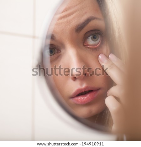 closeup of young woman looking into mirror. mirror reflection of beautiful girl eyes