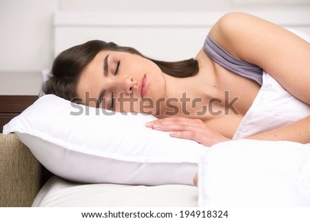 beautiful young lady sleeping in bed. attractive girl lying on cushion and dreaming