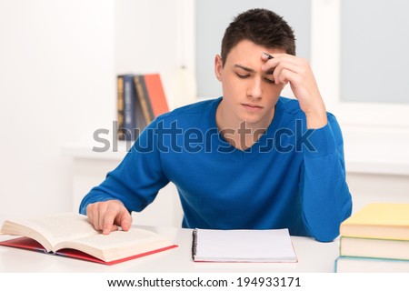 young attractive student studying homework. handsome man reading and writing lessons
