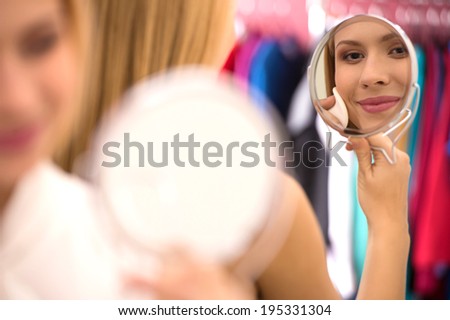 beautiful young woman looking into mirror. Attractive blond girl cleaning face