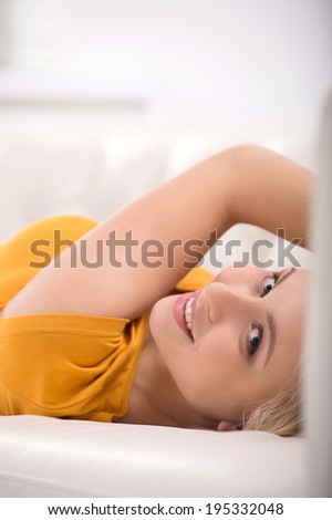 beautiful young girl lying and smiling. pretty blond looking over shoulder and resting