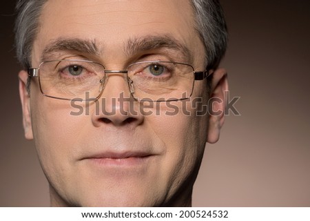 closeup portrait of man wearing glasses. man with glasses smiling isolated on brown background