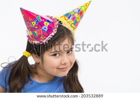 funny girl wearing birthday hat. school girl playing and goofing around