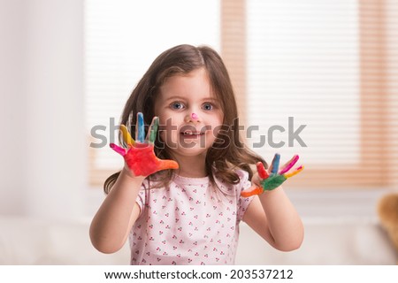 nice little girl with hands in paint. charming girl showing colorful fingers