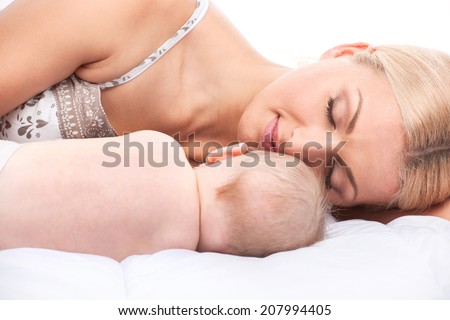 young mom lying in bed with baby. beautiful blond sleeping with little toddler