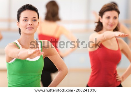 waist up portrait of instructor with fitness class. young girls performing step aerobics exercise in gym
