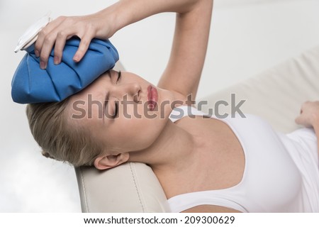 Close up portrait of woman feeling headache. beautiful woman holding ice bag to head