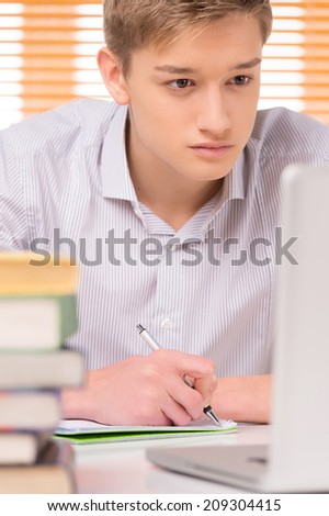 university student writing paper work. closeup of student preparing to exams at home