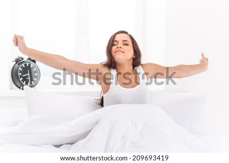 Beautiful young girl lying in bed. Young beautiful, woman waking up fully rested.