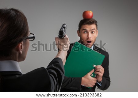 quarrel between man and woman over white background. back view of woman sitting on chair and pointing at man with gun