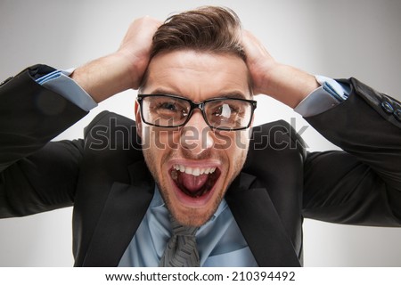 Closeup portrait of angry, frustrated man, pulling his hair out. Negative human emotions and facial expressions