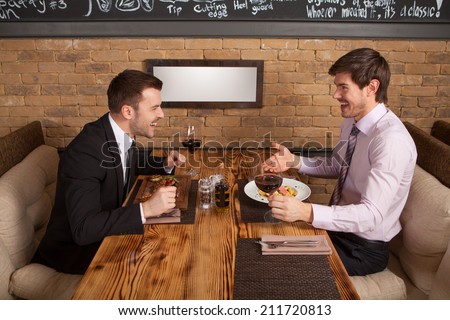 two friends sitting in cafe and eating lunch. two colleagues met in restaurant to discuss business