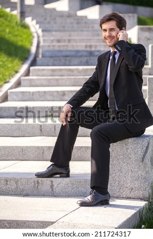 Businessman using mobile phone and sitting. handsome guy talking on mobile phone and smiling