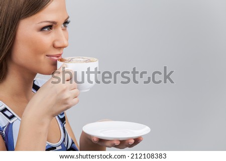 Happy beautiful woman with coffee cup in hands. pretty brunette holding cup and drinking coffee