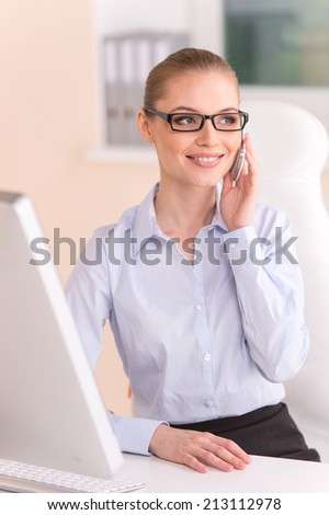 blond businesswoman talking on phone in office. cute young office worker using cell phone