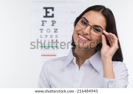 Portrait of happy smiling young woman. girl holding glasses in eye doctor, isolated over white background