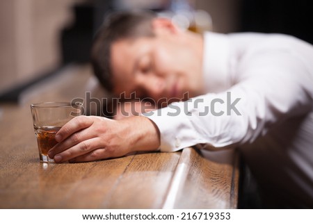 Drunk and unconscious guy lying on counter. man sleeping after hard day in bar