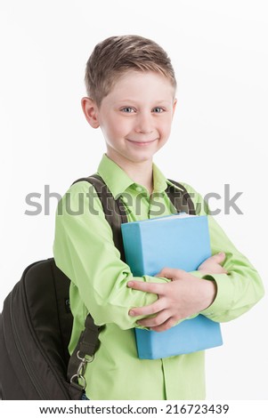 waist up of schoolboy with backpack, isolated on white background. boy holding blue book and smiling