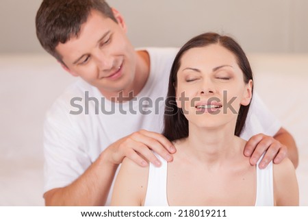 Lovely boyfriend massaging girlfriend\'s shoulders. man massaging woman back at home