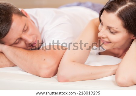 woman looking at man and lying in bed. young lovely couple lying in bed