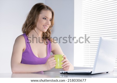 Young Beautiful Woman Using Laptop Indoors. Pensive woman with laptop - isolated over white background