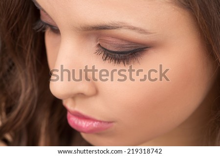 Portrait of attractive girl with make-up looking down. Beauty portrait of young woman looking down