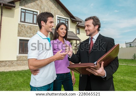 Young couple signing renting contract with real estate agent. agent giving pen to sign agreement for house sale