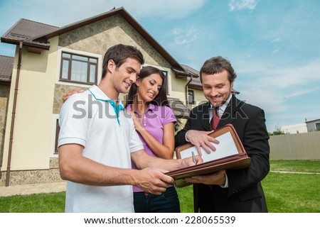Young man signing renting contract with real estate agent. agent holding documents to sign agreement for house sale