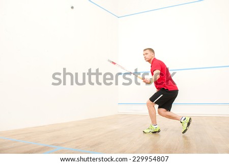 squash player hiting ball in squash court. man playing match of squash alone