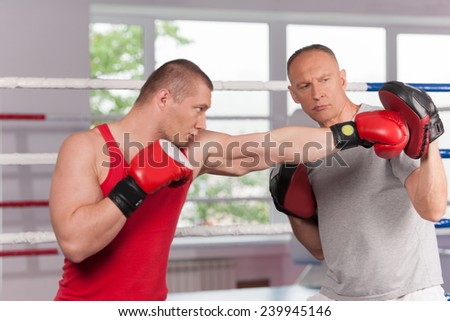 boxer and his coach doing some sparring in ring. Boxer and his coach practicing some moves