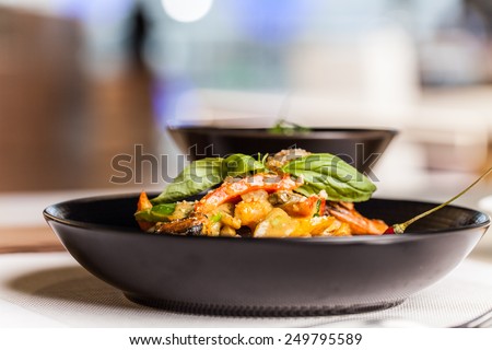 closeup on black plate with hot food. side view on tasty desert with blurred background