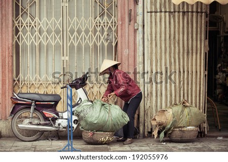 Hanoi, Vietnam - 3 MARCH: Women with baskets on the street of Hanoi, March 3, 2014.