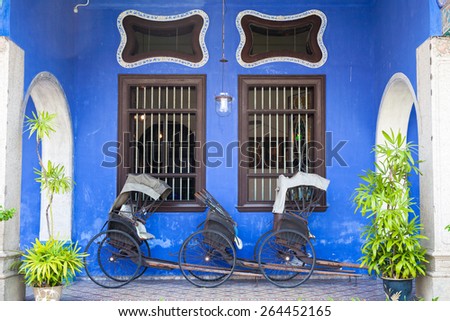 Georgetown Malaysia 04 August 2014 Old rickshaw tricycle near Fatt Tze Mansion or Blue Mansion famous oriental historical building in Georgetown Penang Malaysia on 04 August 2014 Georgetown Malaysia 04 August 2014 Old rickshaw tricycle near Fatt Tze Mansion or Blue Mansion famous oriental historical building in Georgetown Penang Malaysia on 04 August 2014