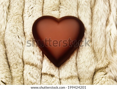 Deep red heart on fox fur blanket.
